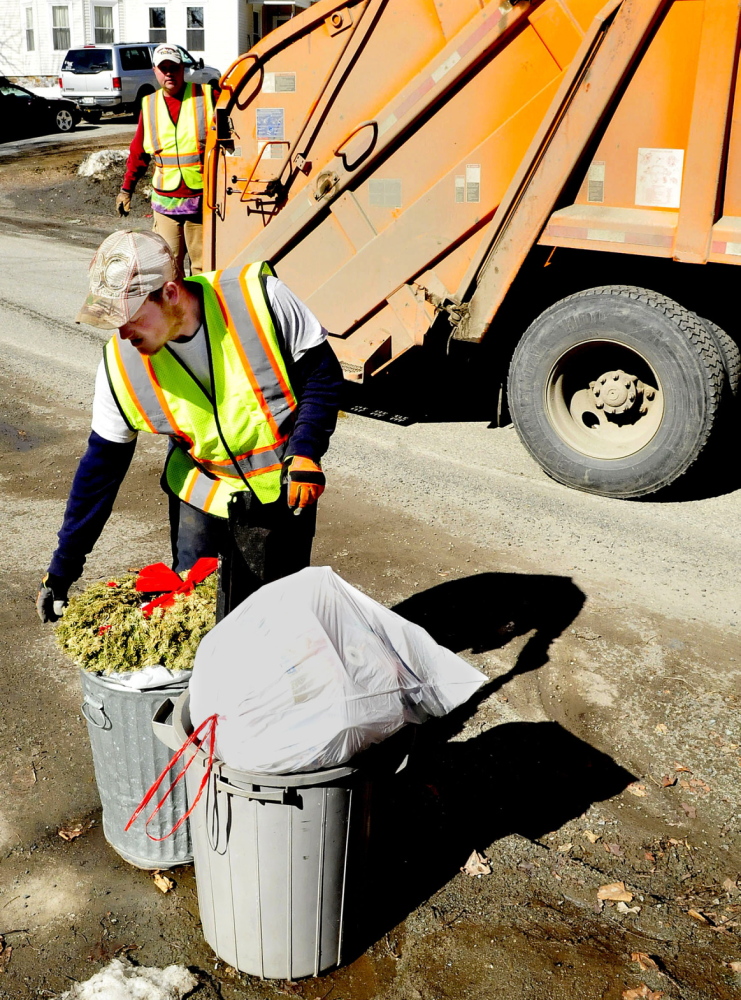 WASTE NOT: Waterville Public Works department employees Larry Colson, front, and Brian Ames pick up trash on Wednesday, April 2, 2014. The city is considering alternatives to solid waste removal.