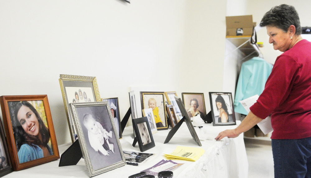 Staff photo by Andy Molloy Mary Wakefield examines photos of homicide victims Sunday during the annual luncheon of the Maine chapter of Parents of Murdered Children in Augusta. At left is a portrait of Brooke Locke, who was 21 whe she murdered in November 2013 at a Bangor apartment that she shared with the alleged killer. Wakefield of Waterville is the mother of Rhonda Wakefield, who was murdered by her estranged husband in 2007 in Fairfield.
