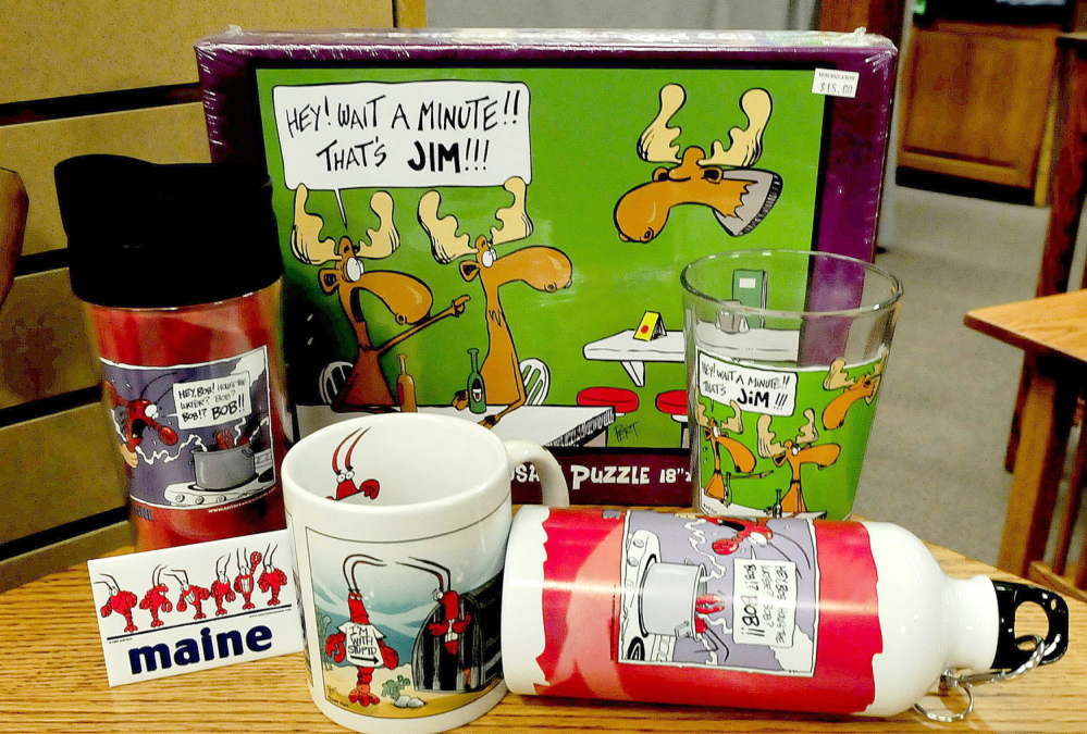 MAINE HUMOR: Magnets, coffee and drinking cups and a puzzle created by cartoonist Jeff Pert, of Winslow, are popular items sold at the Maine Made Shop in Waterville. Pert died on Friday.