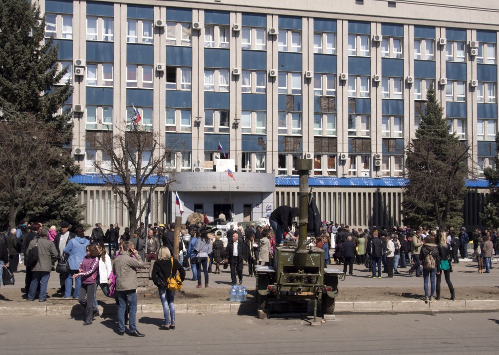 Pro-Russian activists gather in front of an entrance of the Ukrainian regional office of the Security Service in Luhansk, 20 miles west of the Russian border, in Ukraine, Tuesday. The Donetsk and Kharkiv regions and a third Russian-speaking city besieged by pro-Moscow activists over the weekend, Luhansk, have a combined population of nearly 10 million out of Ukraine’s 46 million, and account for the bulk of the country’s industrial output.