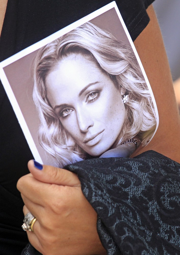 A mourner holds a program with a photo of Reeva Steenkamp at her funeral in 2013 in Port Elizabeth, South Africa.