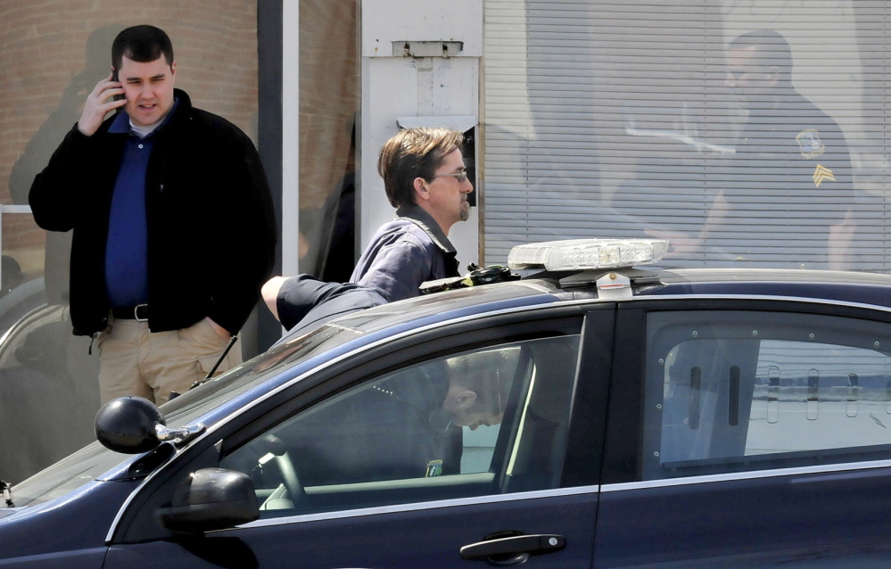 ARRESTED: Peter Corson is searched after his arrest by Waterville police at 12 Spring St. in Waterville on Thursday.