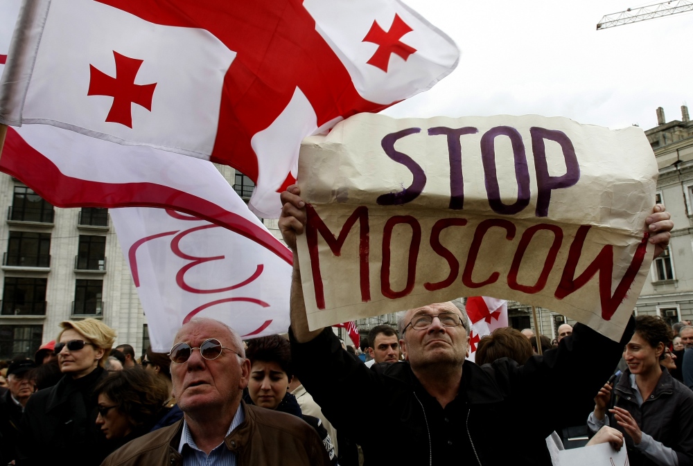 Demonstrators hold a Georgian national flag and a poster during a rally in support of Ukraine in Tbilisi, Georgia, on Sunday.