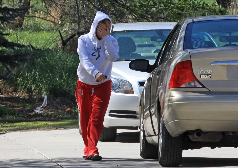 A unidentified family member leaves the house where seven infant bodies were discovered and packaged in separate containers at a home in Pleasant Grove, Utah, on Monday.