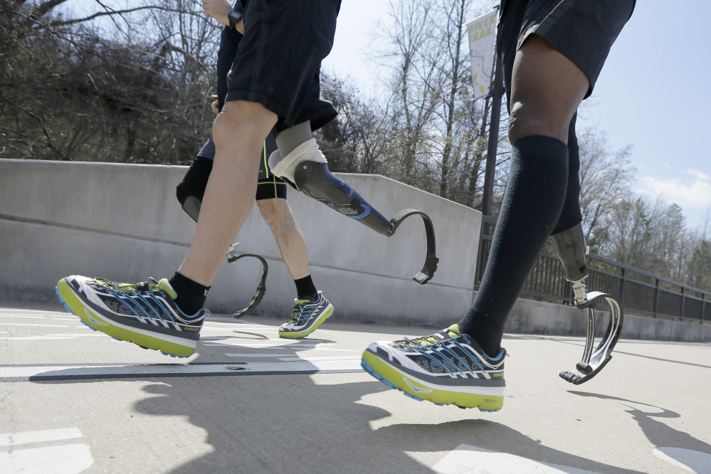 Amputee marathon runners Andre Slay, right, Chris Madison, back, and Jeff Glasbrenner train in Little Rock, Ark., this year, 4,781 runners are taking the Boston Marathon up on its offer to return – an opportunity to settle some unfinished business when they line up at the start again.