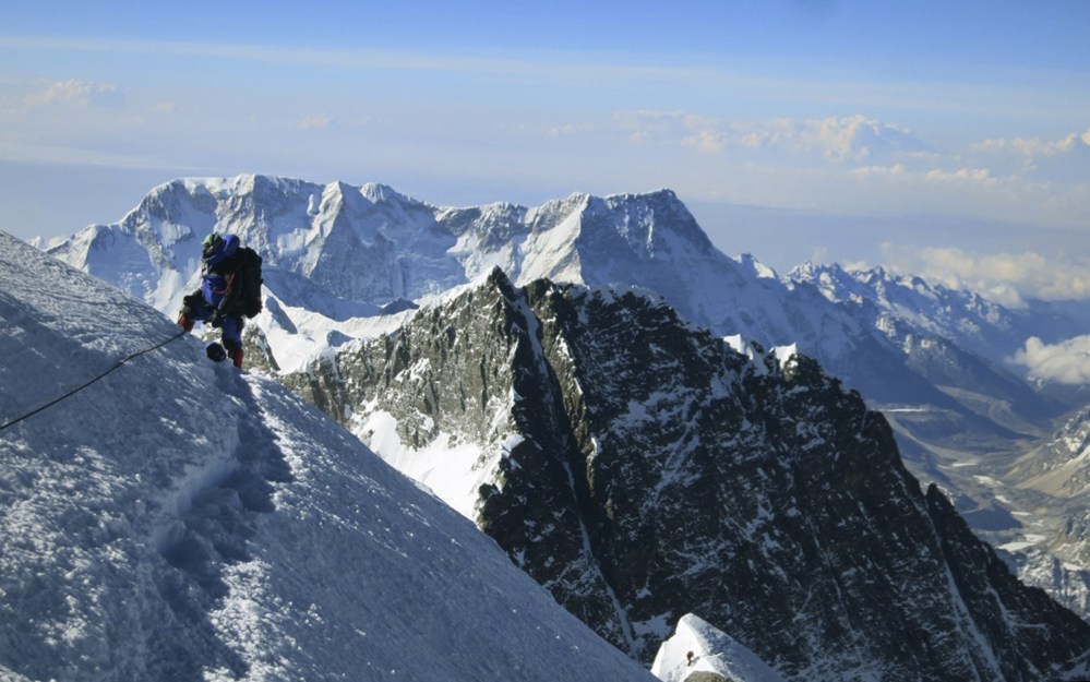 In this May 18, 2013, photo provided by mountain guide Adrian Ballinger of Alpenglow Expeditions, a climber pauses on the way to the summit of Mount Everest. Hundreds of climbers, their guides and support crews have gathered at the base camp to prepare for attempts to scale the 29,035-foot mountain early next month when weather conditions become favorable.