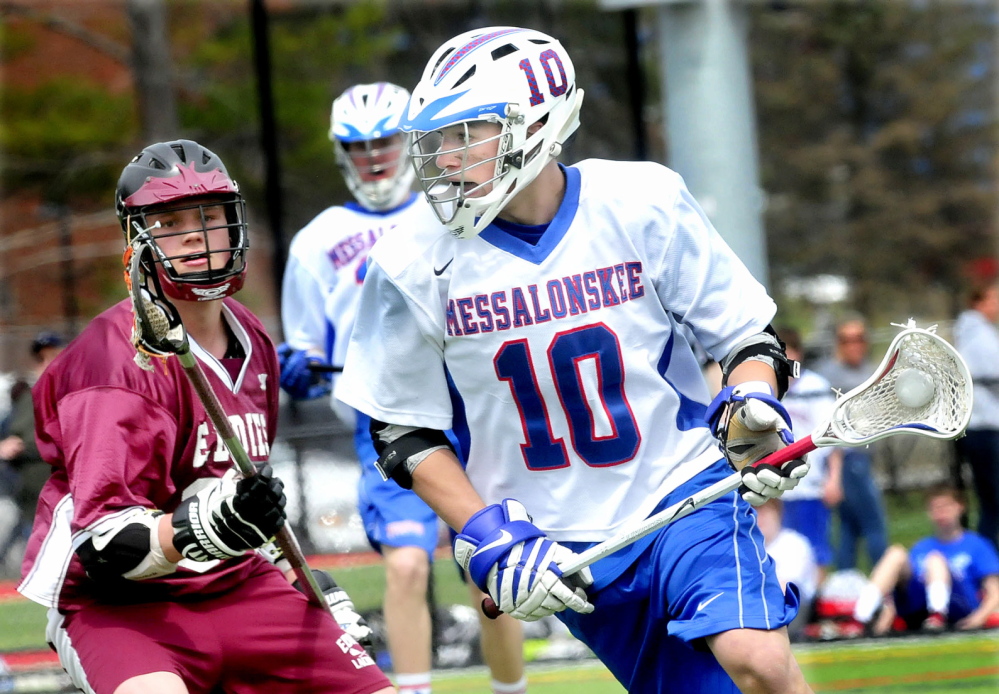 Staff photo by David Leaming Messalonskee High school player Jack Bernachez fields ball past Edward Little's Jack Adams in Waterville on Tuesday, April 22, 2014.