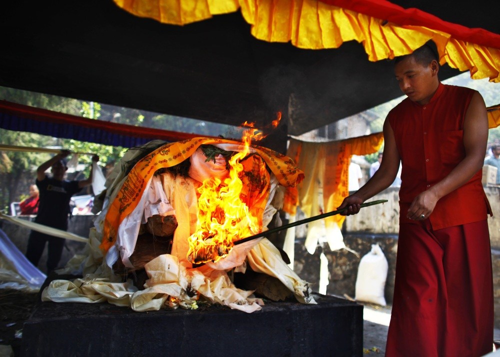 A Buddhist monk lights the funeral pyre Monday of Nepalese climber Ang Kaji Sherpa, who was killed in the Mount Everest avalanche. Monks cremated the remains of Sherpa guides who were buried in the deadliest avalanche ever recorded on Everest, a disaster that has prompted calls for a climbing boycott by Nepal’s ethnic Sherpa community.