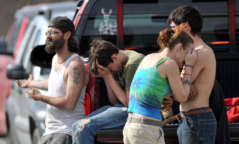 DISTRESS: Jessica Alley leans on Chris Alley, left, during a fire at her home on Winslow Road in Albion Friday. Her brother, Charles Frost Jr., left, watches firefighters.