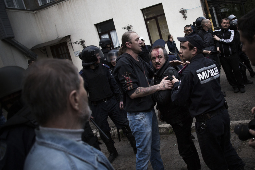 A pro-Ukrainian man bleeds after been beaten by pro-Russians during a pro-Ukraine rally in Donetsk, Ukraine, on Monday. About a thousand pro-Russian activists armed with sticks and steel rods attacked participants in the pro-Ukrainian rally in center of Donetsk.