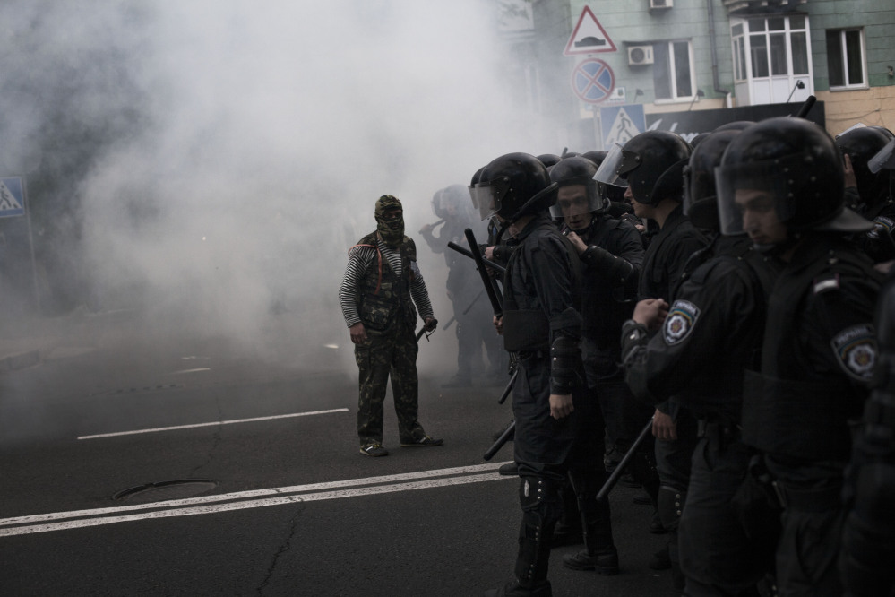 A pro-Russian activist shouts to police after the explosion of a gas device during a pro-Ukraine rally in Donetsk, Ukraine, on Monday.