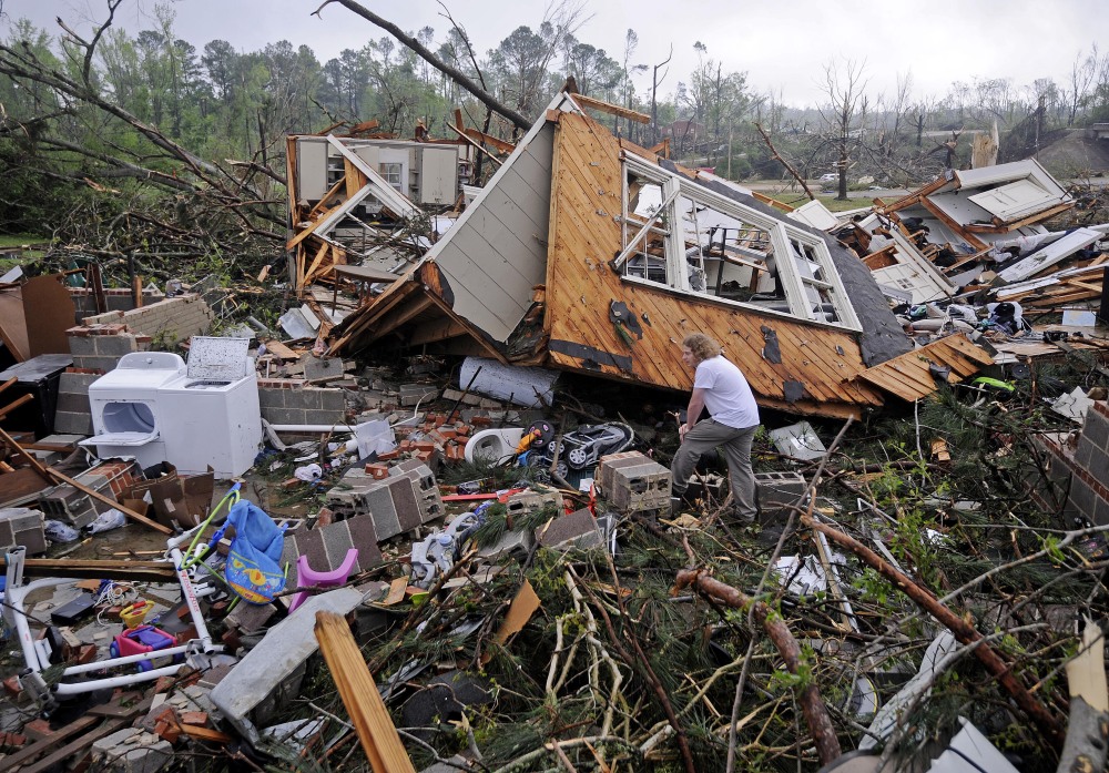 Kevin Barnes searches the remains of his home Tuesday in Tupelo, Miss.