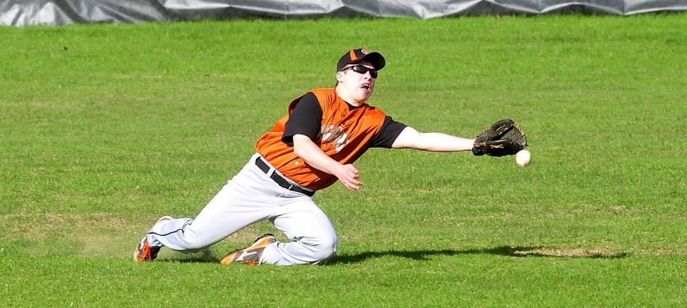Staff photo by David Leaming Gardiner's Josh Ferrin reaches for fly ball in center field during game against Waterville on Monday, May 5, 2014.
