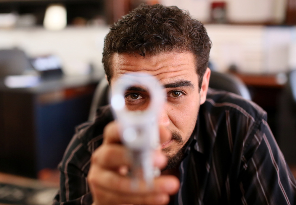 Dimitri Karras displays an unfinished receiver for an AR-15 rifle at his store in Oceanside, Calif. It appeals to customers who appreciate the fact that the parts have no serial numbers, says Karras, who expects to sell about 75,000 receivers this year.