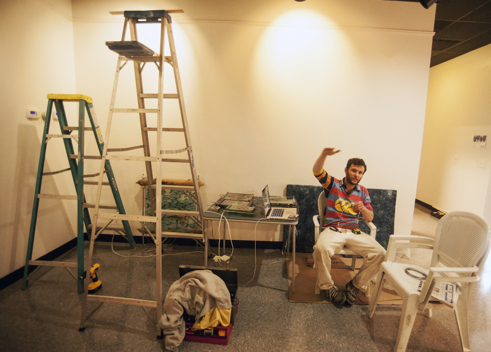 NEW LOBBY: Local artist Thom Klepach prepares a work of art to be hung on the new walls of the lobby at Railroad Square Cinemas in Waterville on Thursday.