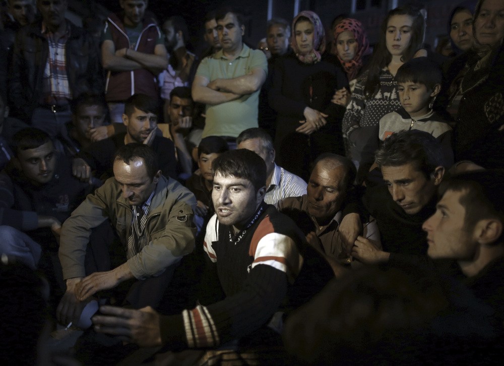 Erdal Bicak, center, speaks to journalists as fellow miners and their relatives commemorate the Soma mine accident and protest the government’s labor policy in Savastepe, Turkey, late Friday.