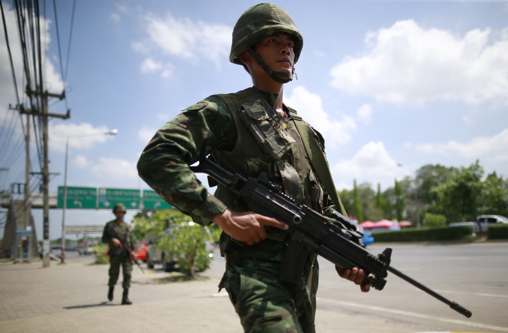 Thai soldiers patrol a road near the rally site for pro-government demonstrators on the outskirts of Bangkok, Thailand, on Thursday. The opponents in Thailand’s polarizing political crisis prepared Thursday for a second round of talks mediated by the country’s army chief, who says he invoked martial law and then summoned the bitter rivals to try to end six months of turmoil.
