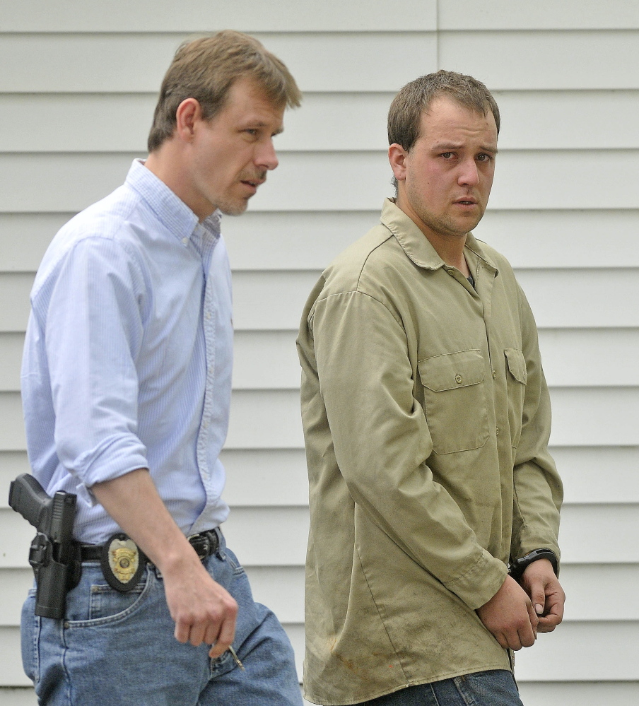 ARRESTED: David Devine, 25, is escorted to a police cruiser Friday at the Oakland Police Department by officer Jeff Coombs after being booked on two counts of aggravated assault.