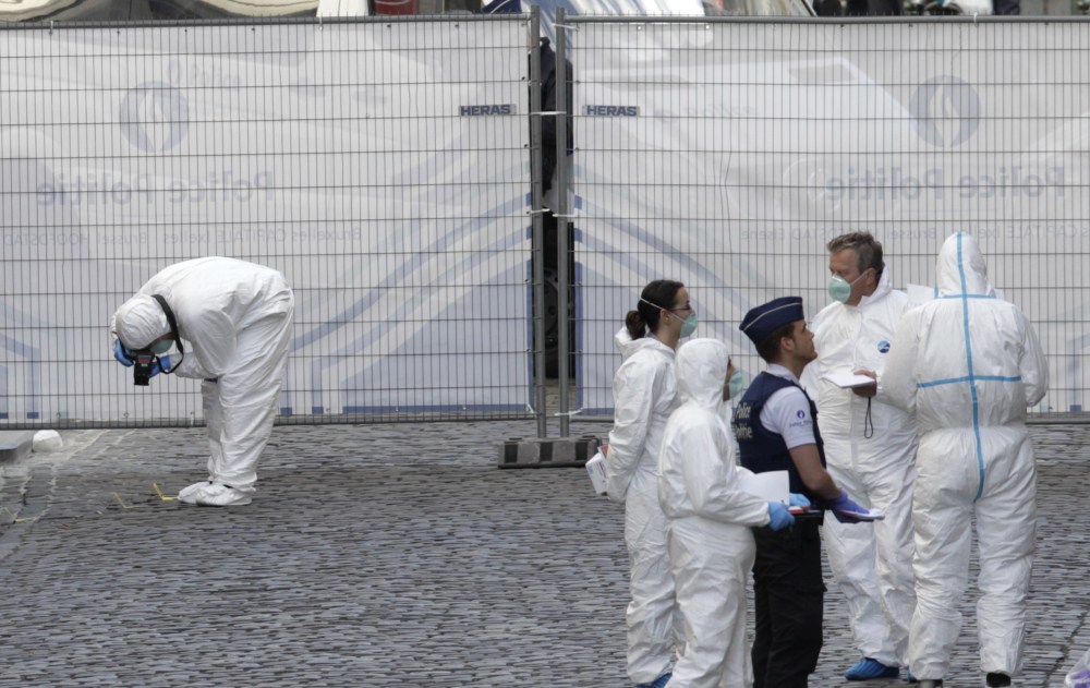 Forensic experts examine the site of a shooting at the Jewish museum in Brussels on Saturday. Belgian officials say that at least three people have been killed in gunfire at the Jewish Museum in Brussels.