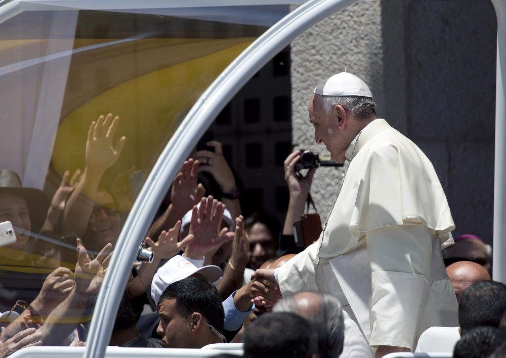 Pope Francis shakes hands with a member of the crowd at Manger Square outside the Church of the Nativity, revered as the site of Jesus’ birth, in the West Bank town of Bethlehem on Sunday.