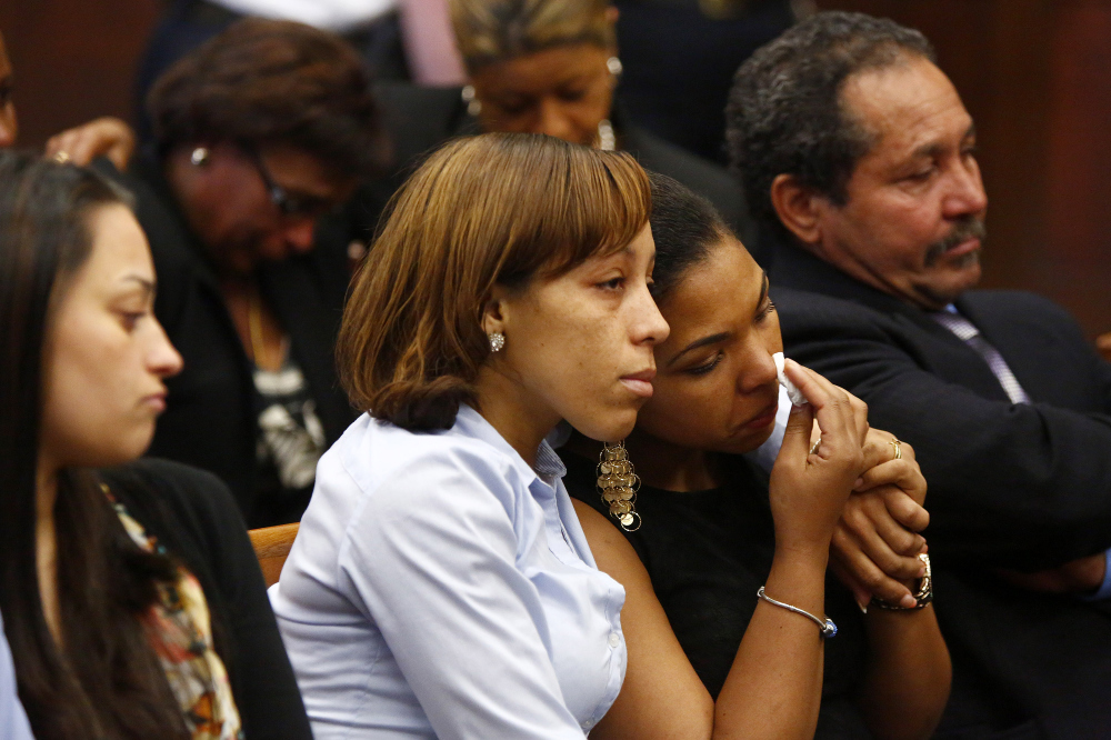 People identified by the district attorney as a victim’s family members of react as they wait for former New England Patriots player Aaron Hernandez to appear at Suffolk Superior Court in Boston, Mass., on Wednesday, May 28, 2014. Hernandez is accused of gunning down two men he did not know in 2012 because one of them bumped into him while dancing at a Boston nightclub. Hernandez pleaded not guilty.