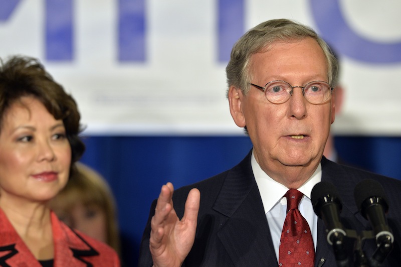 With his wife, Elaine Chao, looking on, Kentucky Sen. Mitch McConnell addresses his supporters following his victory in the Republican primary Tuesday at the Marriott Louisville East in Louisville, Ky.