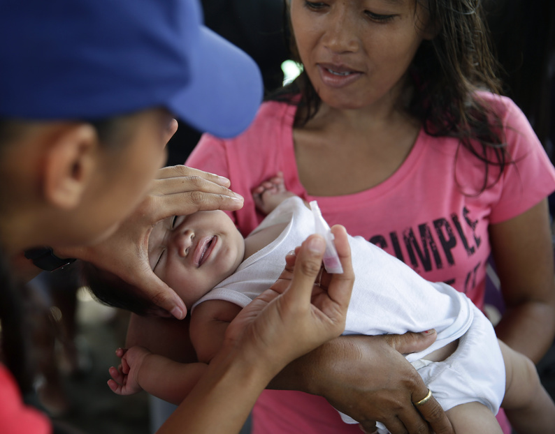 Red Cross and UNICEF medics administer polio and measles vaccinations to typhoon survivors after Typhoon Haiyan ravaged the city of Tacloban, Leyte province in central Philippines.