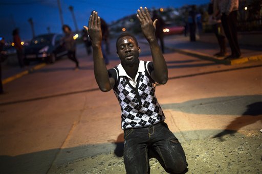 A sub-Saharan migrant prays in front of a temporary center for immigrants after scaling a fence that divides Morocco and the Spanish enclave of Melilla in North Africa.