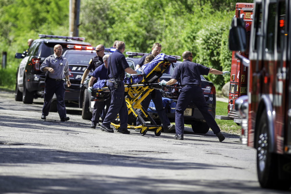 Rescue workers take a stabbing victim to an ambulance in Waukesha, Wis., on Saturday. Two 12-year-old girls are charged in the attack.