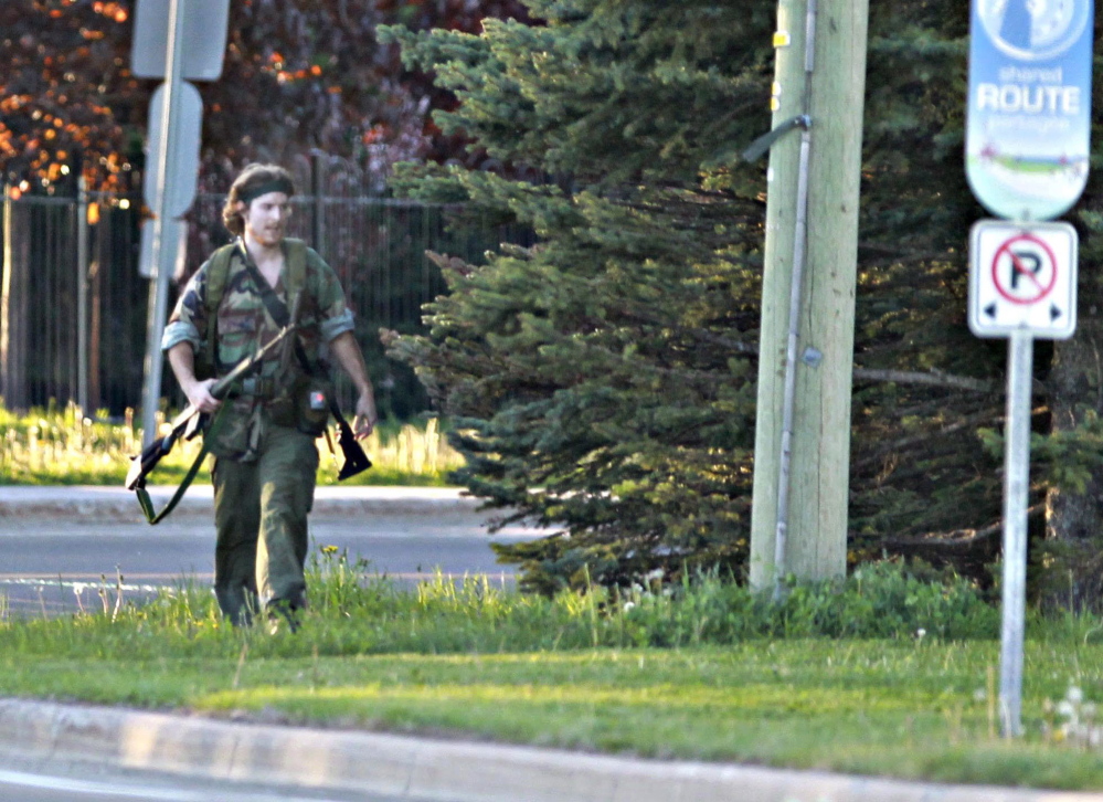 The Associated Press/The Canadian Press, Moncton Times & Transcript, telegraphjournal.com, Viktor Pivovarov A heavily armed man whom police have identified as Justin Bourque walks on a street in Moncton, New Brunswick, on Wednesday after shots were fired in the area. The man is suspected of killing three Royal Canadian Mounted Police officers.