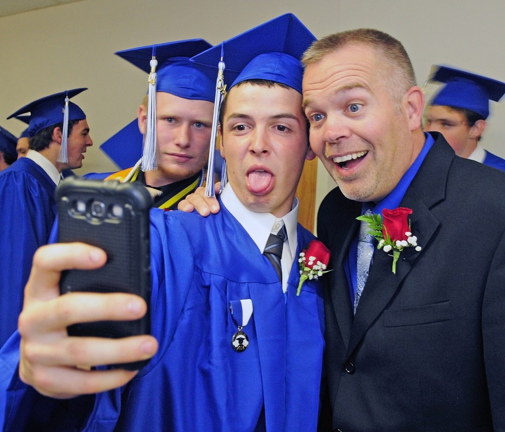 Staff Photo by Joe Phelan GRADUATION: Nick Mason, center, takes a selfie with fellow senior Jared Gartley, left, and Associate Headmaster Jamie Soule before Erskine Academy graduation on Friday at the Augusta Civic Center.