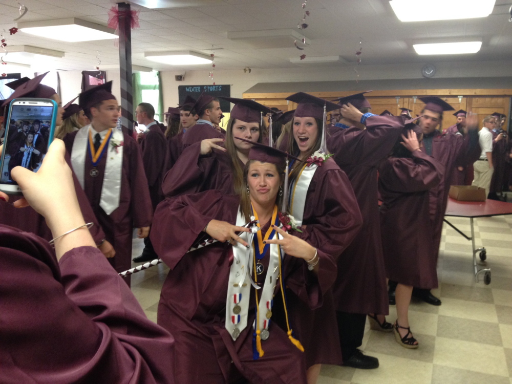Staff Photo by Kaitlin Schroeder GRADUATES: Nokomis graduates Christian Tripoli, left, Anna MacKenzie, middle, and Sadie Ferguson, right,  joke around while taking photos before the commencement ceremony Friday night in Newport.