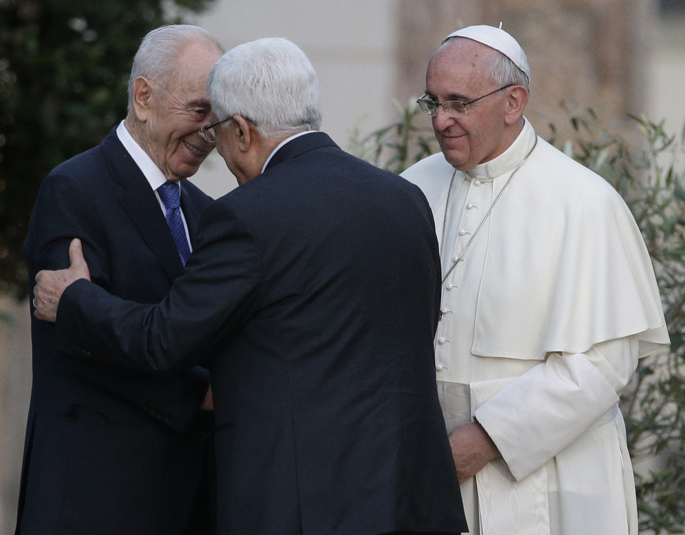 The Associated Press Pope Francis looks as Israel’s President Shimon Peres, left, and Palestinian President Mahmoud Abbas embrace during an evening of peace prayers in the Vatican gardens on Sunday.
