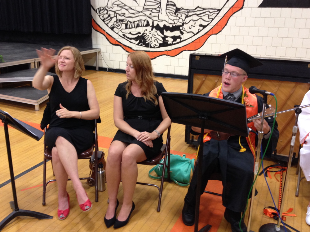 Photo by Matt Hongoltz-Hetling Rainbow: Spencer Lynds, right, plays “Somewhere Over the Rainbow” while an interpreter, left, provided the song lyrics in sign language to an estimated crowd of 800 during the Skowhegan Area High School graduation Sunday afternoon.