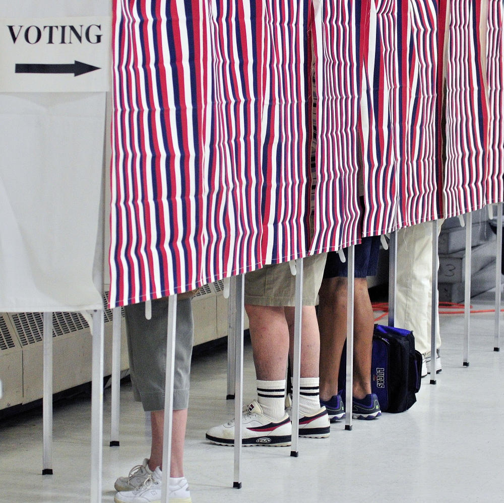 Staff photo by Joe Phelan VOTE: Four voters cast ballots in voting booths around 9:10 a.m. on Tuesday in the Augusta Armory. There was a slow but steady stream of voters in Ward One with three voters waiting to cast ballots in machine at one point.