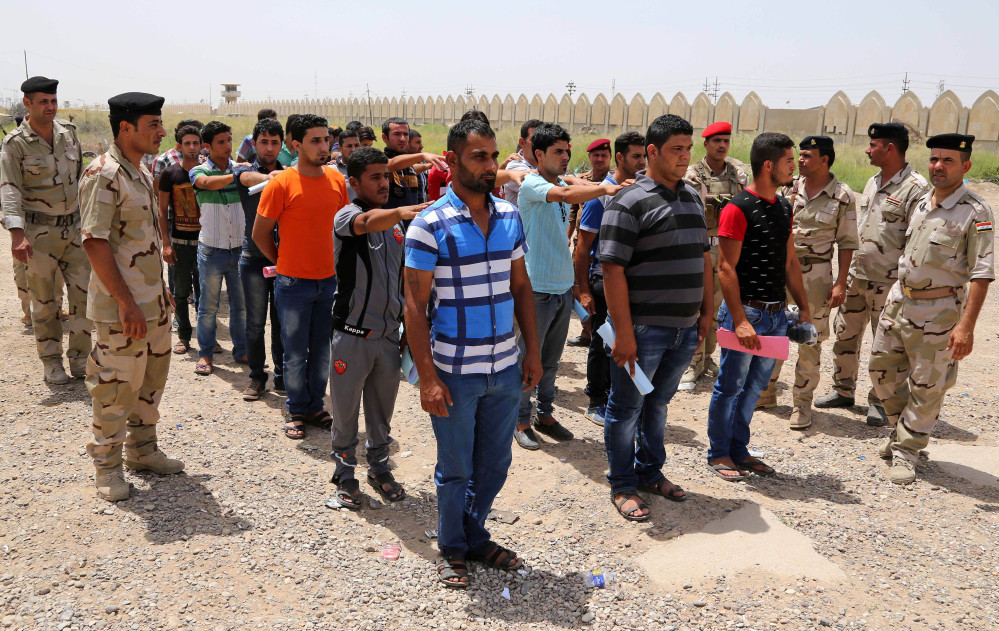 Iraqi men line up outside of the main army recruiting center to volunteer for military service in Baghdad on Thursday after authorities urged Iraqis to help battle insurgents.