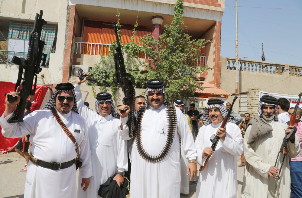 Iraqi Shiite tribal fighters pose with their weapons in Baghdad's Sadr city, Iraq, Saturday, June 14, 2014, after authorities urged Iraqis to help battle insurgents. Hundreds of young Iraqi men gripped by religious and nationalistic fervor streamed into volunteer centers across Baghdad Saturday, answering a call by the country's top Shiite cleric to join the fight against Sunni militants advancing in the north. (AP Photo/Karim Kadim) Iraqi Shiite tribal fighters pose with their weapons in Baghdad’s Sadr city, Iraq, on Saturday after authorities urged Iraqis to help battle insurgents.