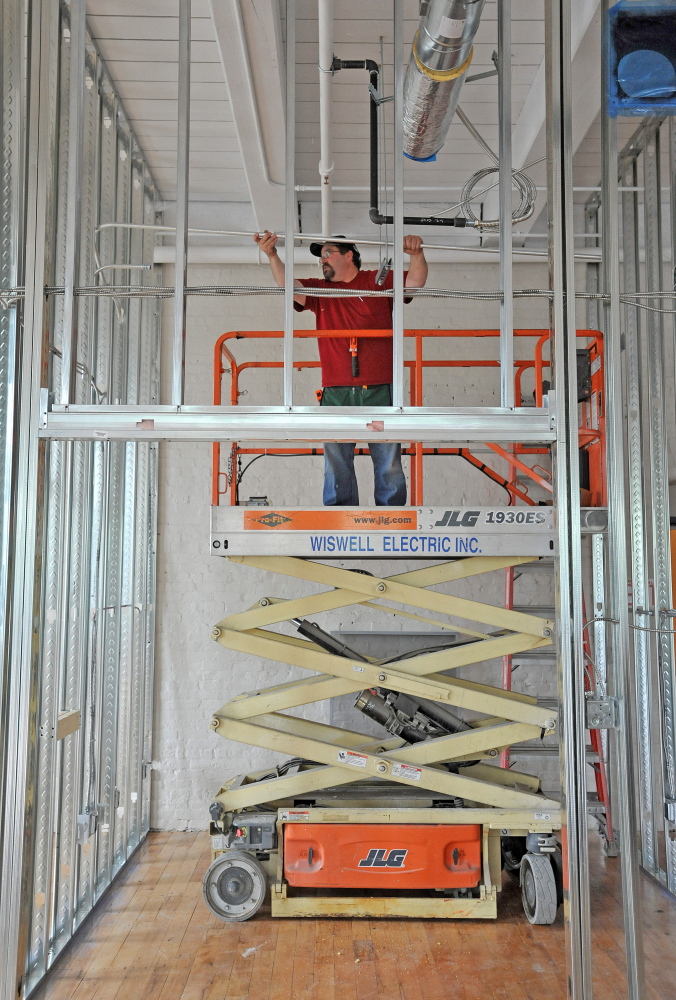 Close up: Contractor Jon Madore installs electrical conduit in a section of new MaineGeneral medical offices in the Hathaway Center on Water Street in Waterville on Thursday. Hathaway Creative Center owner Paul Boghossian said he has invested more than $30 million in the former shirt factory.