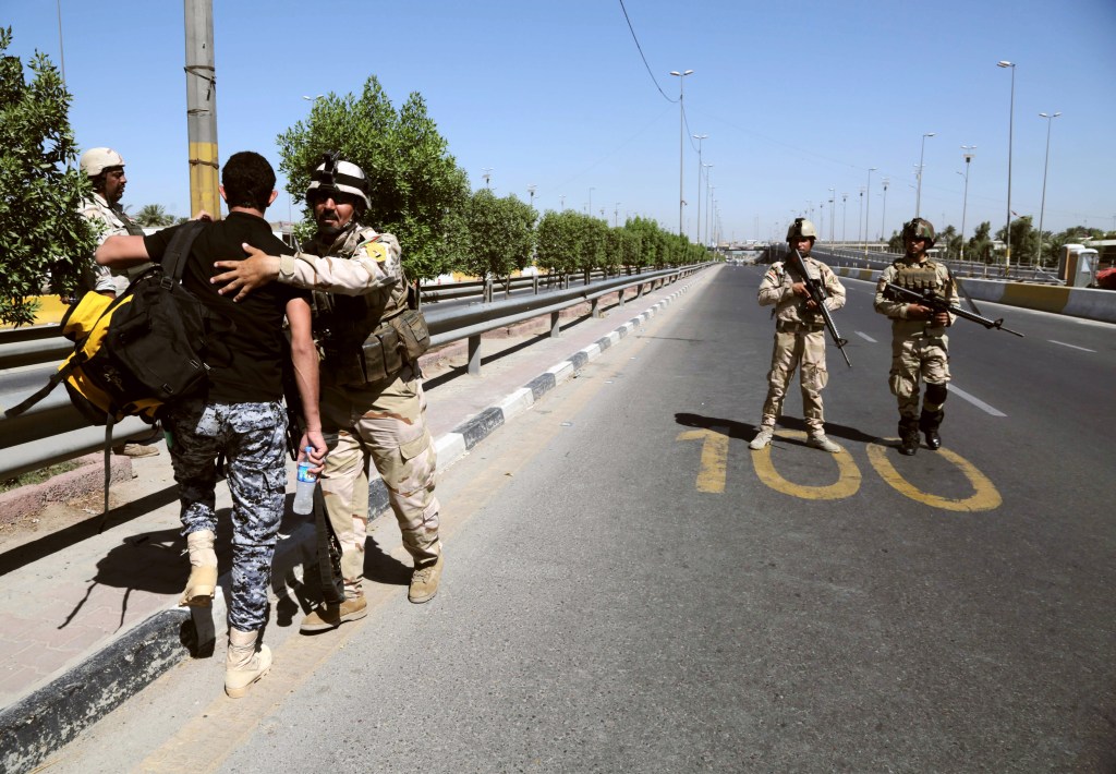 An Iraqi army soldier searches a volunteer outside the main recruiting center in Baghdad on Tuesday. Hundreds of young Iraqi men gripped by religious and nationalistic fervor streamed into volunteer centers across Baghdad Saturday, answering a call by the country’s top Shiite cleric to join the fight against advancing Sunni militants.