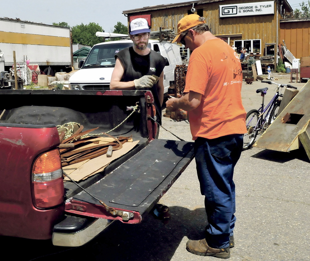 Staff photo by David Leaming
INVENTORY REDUCTION: Robert Dale, left, receives cash for metal items he sold to Patrick Plourde at Maine 201 Antiques in Fairfield on Tuesday. Dale is under a court ordered agreement with the town to comply with town ordinances and clean up his property that has piles of used merchandise.