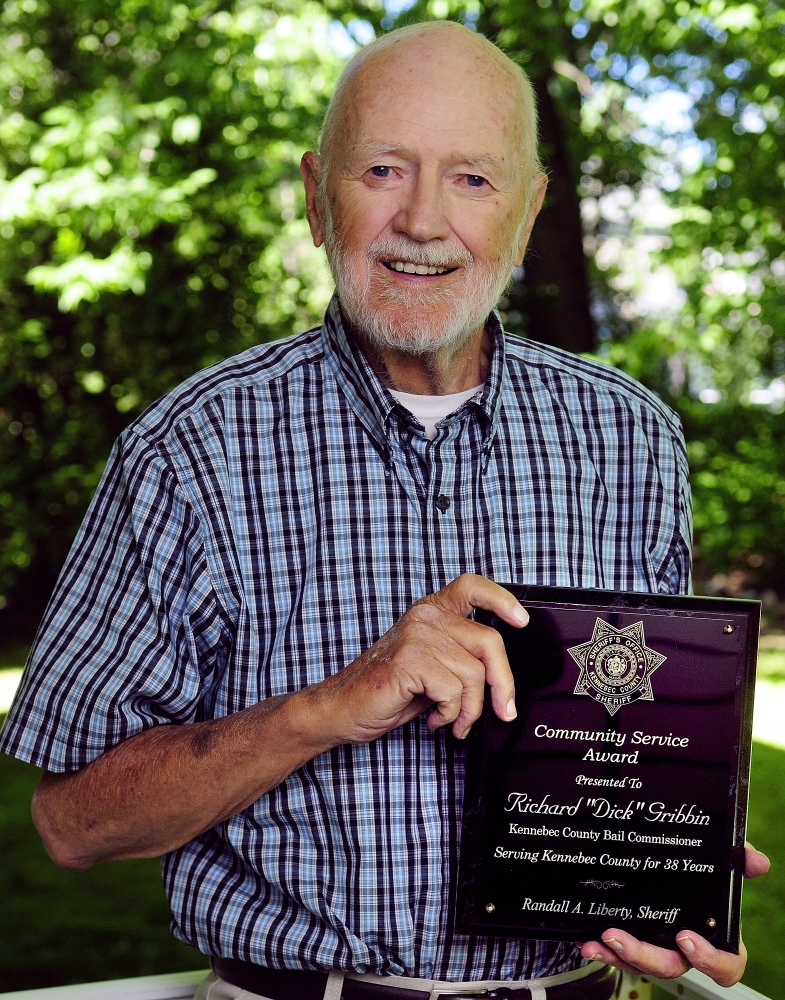 HONORED: Retired bail commissioner Dick Gribbin holds up a plaque he received on Thursday in Augusta to honor his 38 years of service. Gribbin retired in 2013.