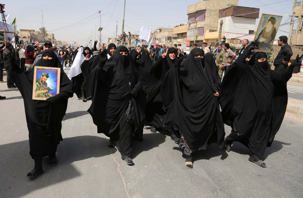 Supporters for the newly formed “Peace Brigades” participate in a parade in the Shiite stronghold of Sadr City, Baghdad, Iraq, Saturday.