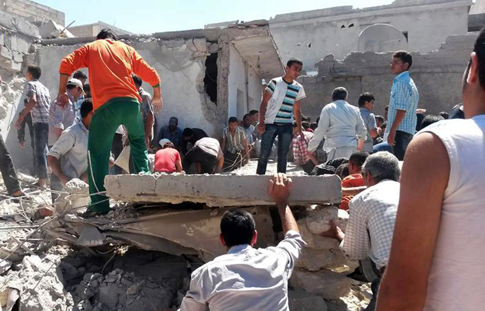 This photo provided by an anti-government activist group shows Syrians inspecting the rubble of destroyed houses following a Syrian government airstrike in Aleppo, Syria, on Wednesday. Syrian government warplanes on Wednesday struck a series of targets in a northern city that is a stronghold of an al-Qaida splinter group.