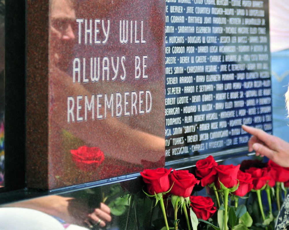 Survivors placed roses in front of the Maine Murder Victims’ Memorial Monument at the end of the dedication ceremony on Sunday in Augusta.