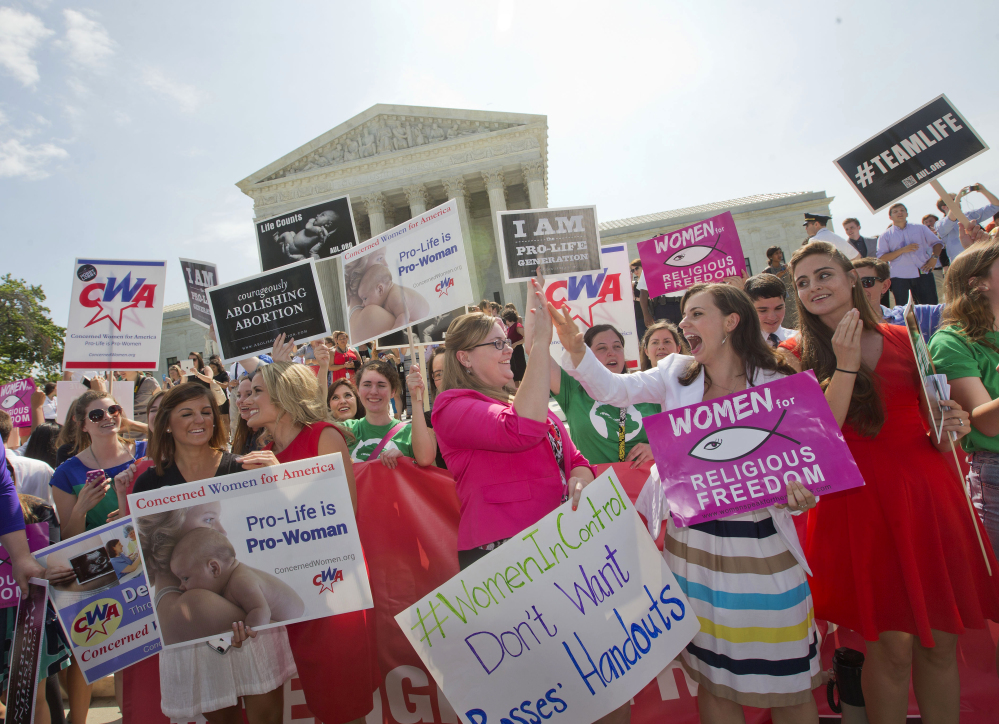 Demonstrator react to hearing the Supreme Court’s decision on the Hobby Lobby case outside the Supreme Court in Washington, Monday.