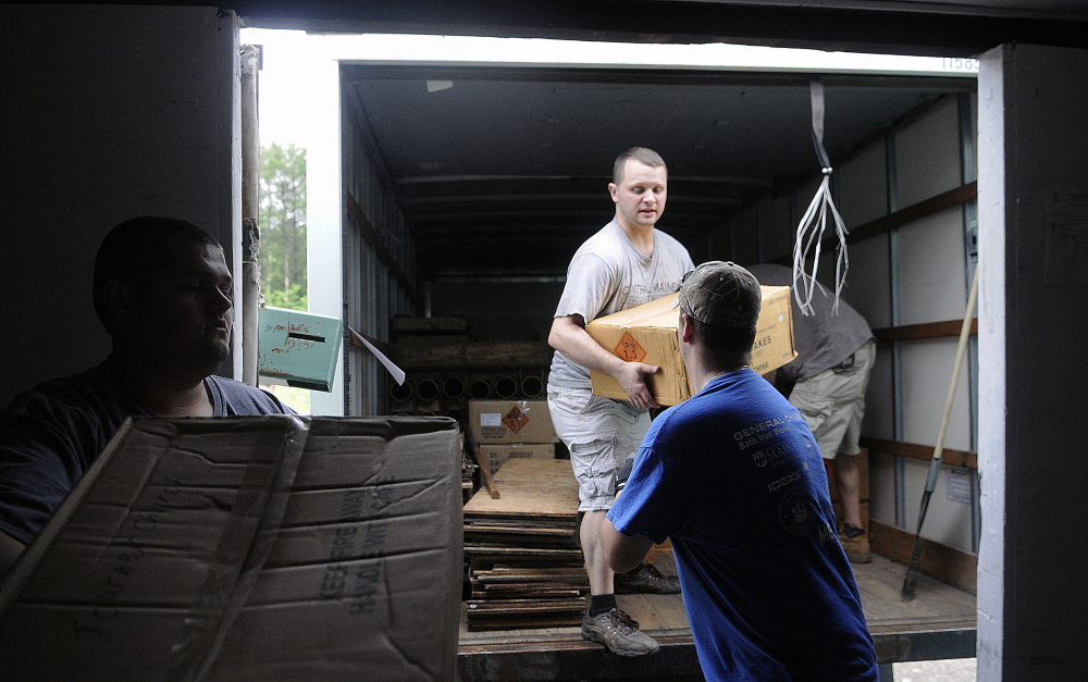 Employees of Central Maine Pyrotechnics transfer fireworks between trucks Thursday in response to shows being rescheduled.