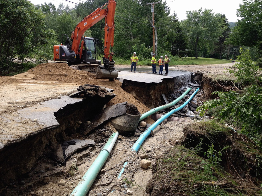 Gordon Chibroski/Staff Photographer
Maine Department of Transportation employees fill half the roadway with sand to create access for emergency vehicles at the corner of Hall Hill and South Rumford roads in Rumford on Thursday, after Wednesday’s storms washed out the roadway.