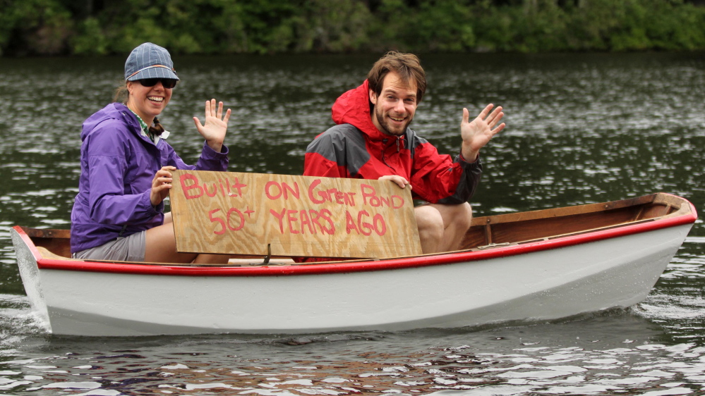 Boaters wave to a crowd lined up along Mill Stream on Saturday to watch the annual boat parade to celebrate Independence Day in Belgrade Lakes village.