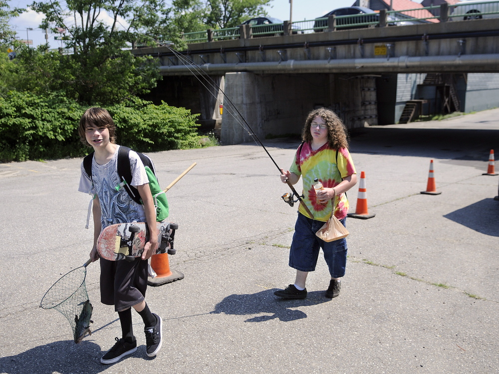 Duncan Washburn, 15, lugs a catfish that his buddy, Jonathan McFadden, 15, caught Tuesday in Cobbossee Stream in Gardiner, where a walking and bicycling is proposed to be built.