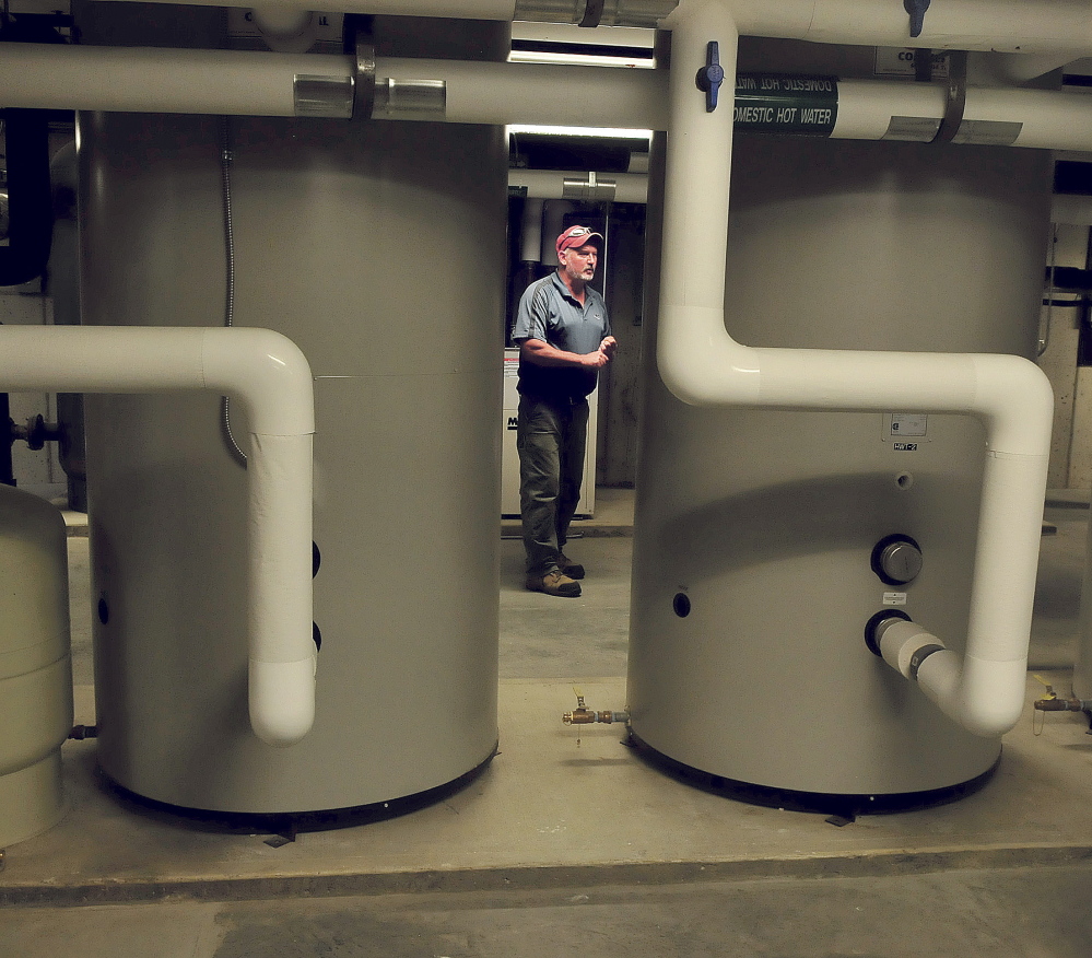 Brookside Village Superintendent Chuck Pollock explains the energy efficient means of heating and providing electricity using geo-thermal and solar power systems at the new senior residence in Farmington on Tuesday.